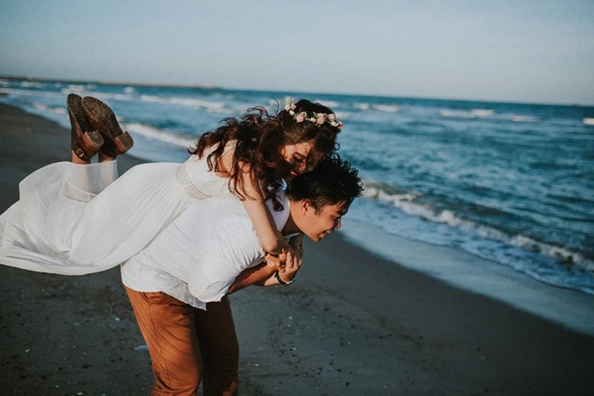 Chú rể vui vẻ cổng cô dâu chạy dọc bờ biển