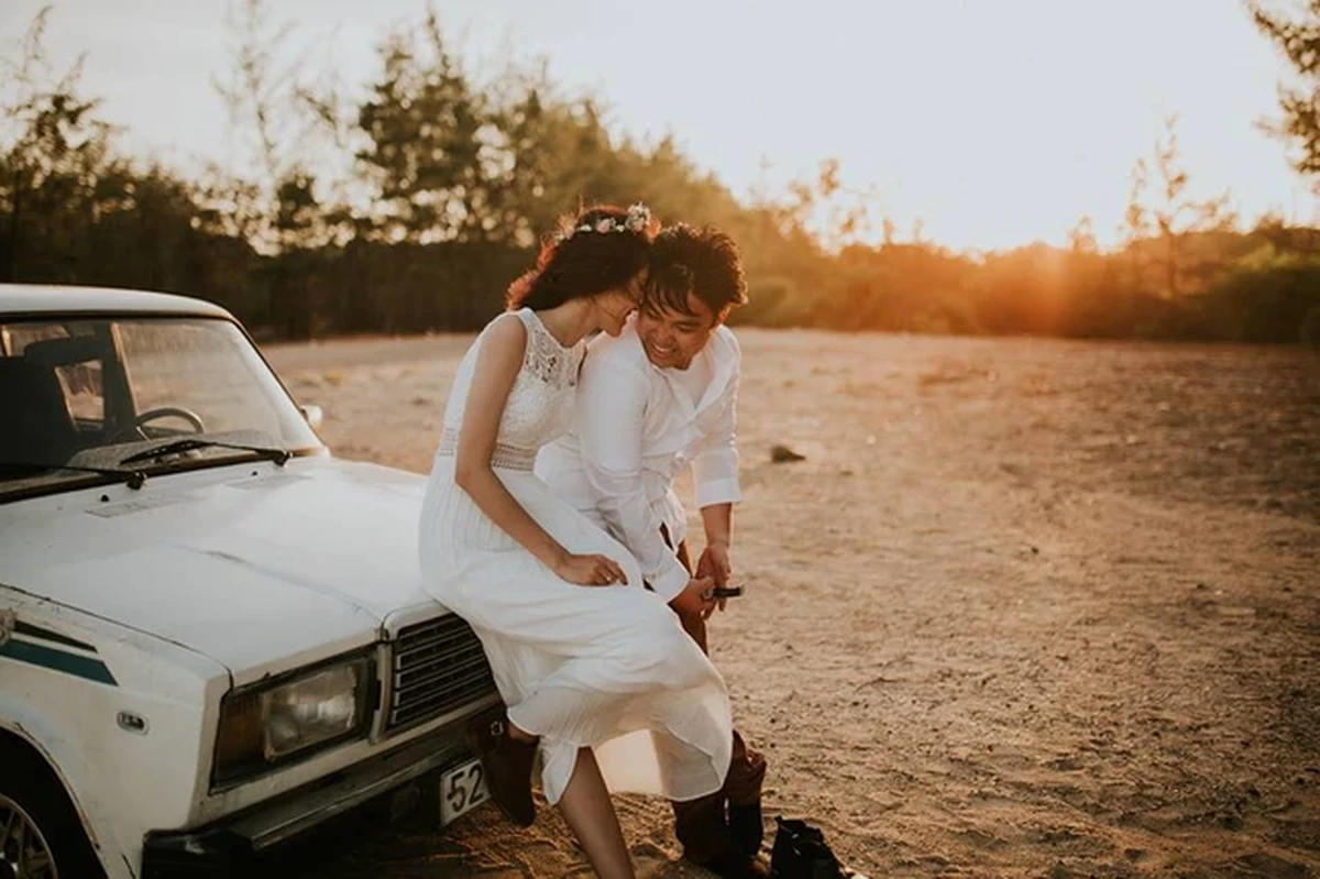 Cả 2 cùng nhau ngồi trước xe ô tô cười đùa hạnh phúc