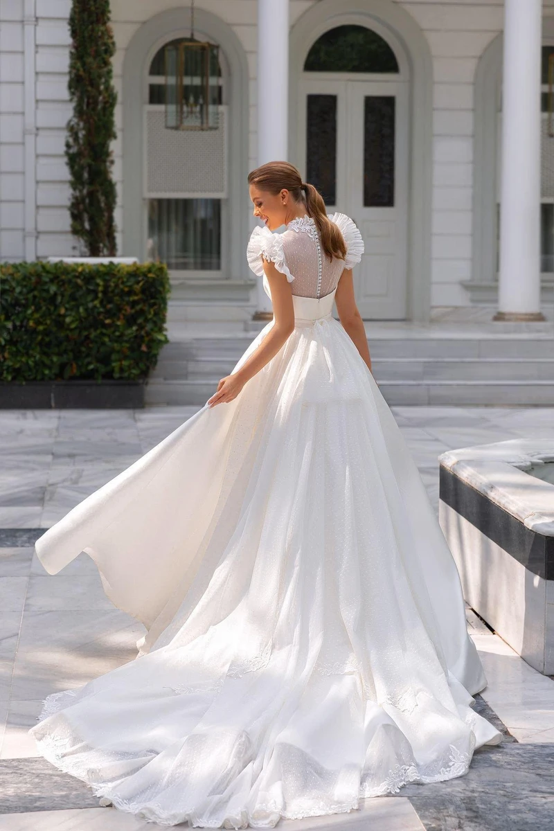Cô dâu diện váy cưới trắng thanh lịch với thiết kế tay bồng, lưng phối vải voan mỏng