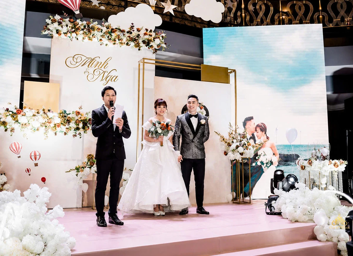 MC đứng trên sân khấu cùng cô dâu chú rể