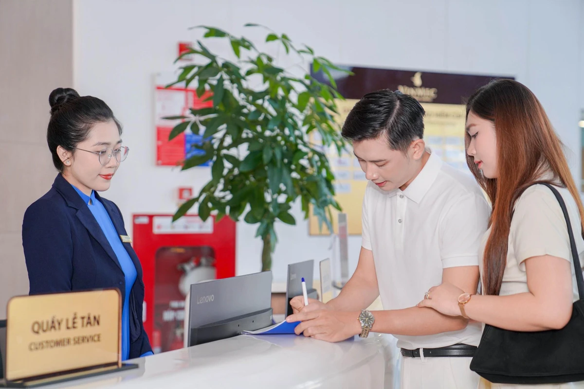 Cặp đôi tập trung điền tờ khai đăng ký thông tin tại quầy lễ tân
