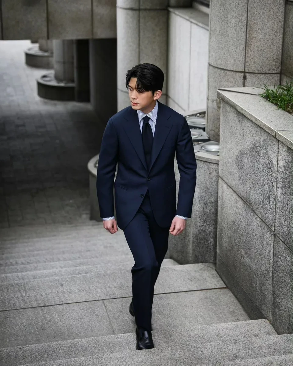 Mẫu nam mặc suit xanh đen phối cùng áo sơmi caro và cà vạt 