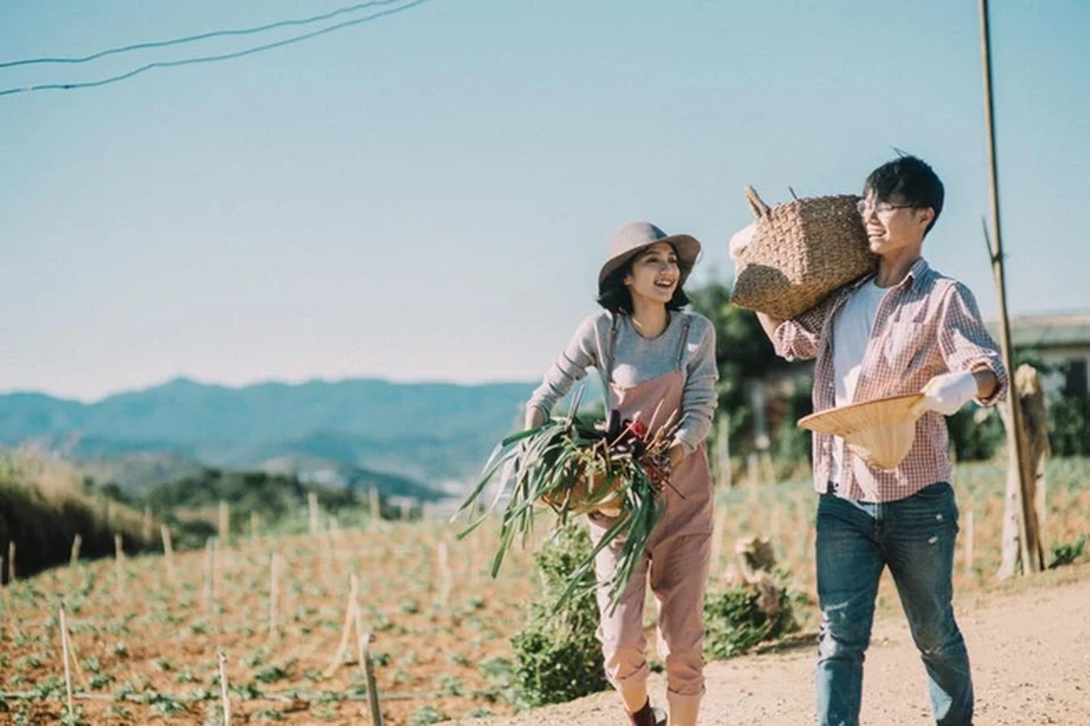 Chàng trai vai vác sọt tre cùng cô gái xách giỏ rau tươi cười dạo bước trên con đường đất