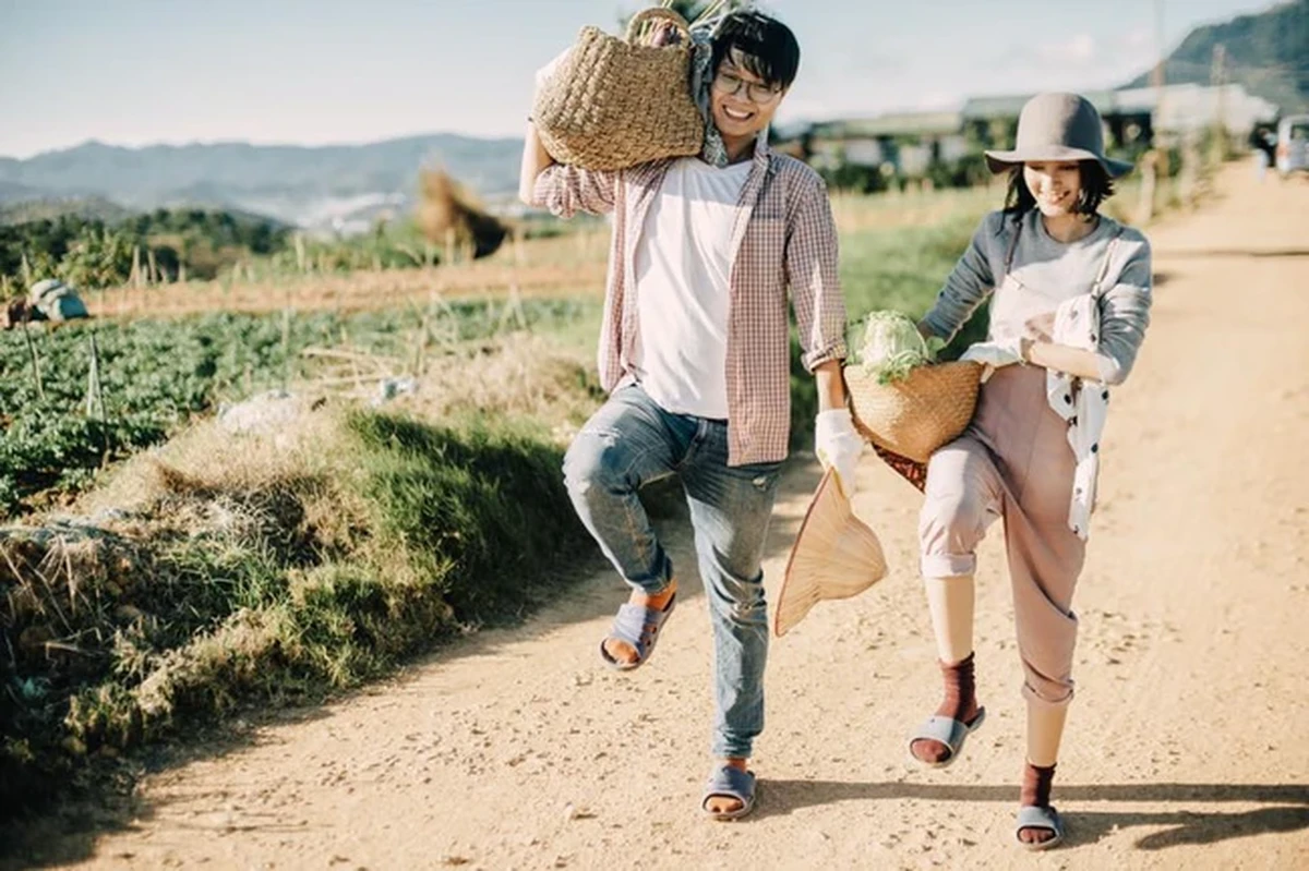 Đôi nam nữ tinh nghịch co một chân đùa giỡn trên đường đất