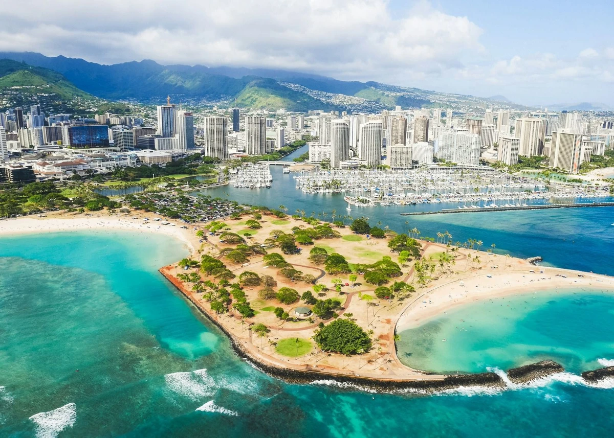 Góc nhìn từ trên cao của bờ biển Honolulu với làn nước xanh ngọc, bến du thuyền và đường chân trời thành phố phía sau
