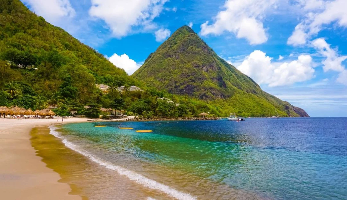 Bãi biển Saint Lucia với làn nước trong xanh và ngọn núi Piton hùng vĩ phía sau bờ biển nhiệt đới