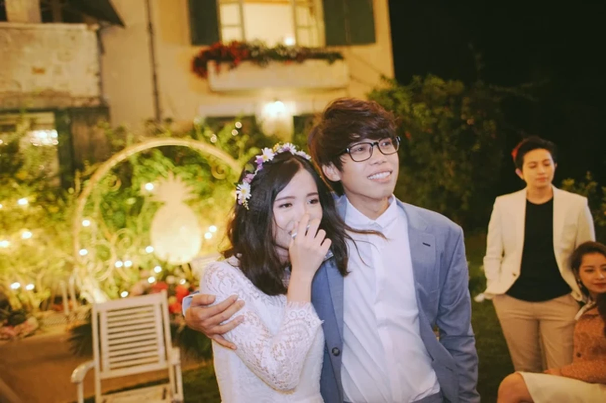 Khoảnh khắc cô dâu chú rể ôm nhau hạnh phúc trong buổi tiệc ngoài trời, ngập tràn ánh đèn ấm áp