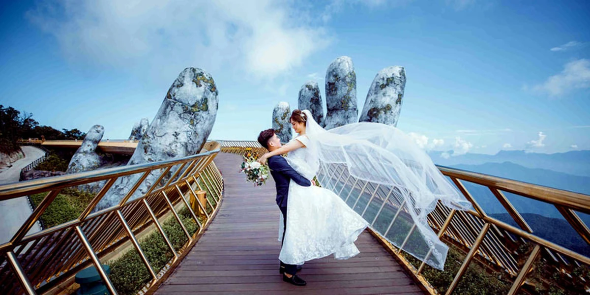 Cặp đôi mặc áo cưới và vest chụp hình tại cầu Vàng Đà Nẵng