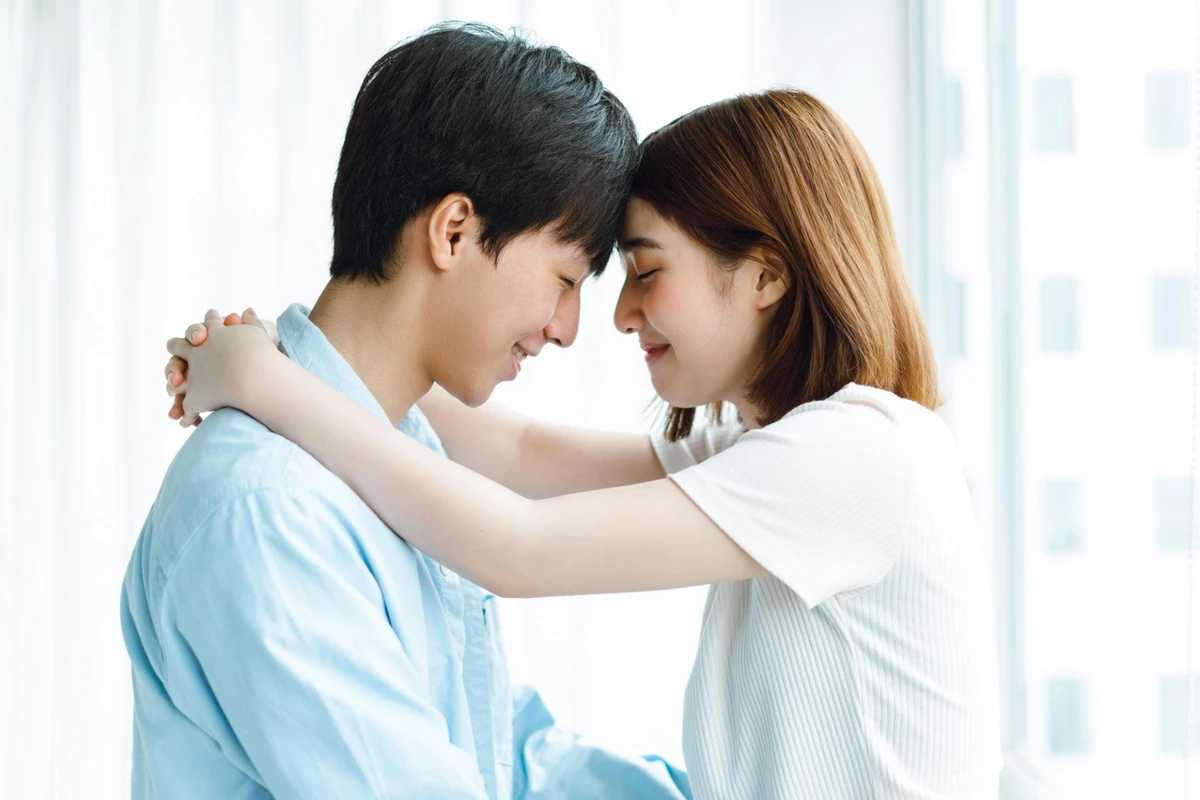 ặp đôi trẻ tựa trán vào nhau mỉm cười hạnh phúc