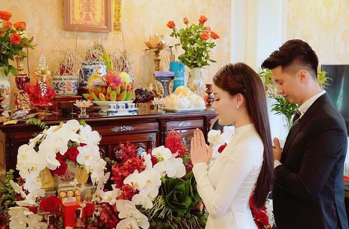 Cô dâu chú rể thắp hương trên bàn thờ