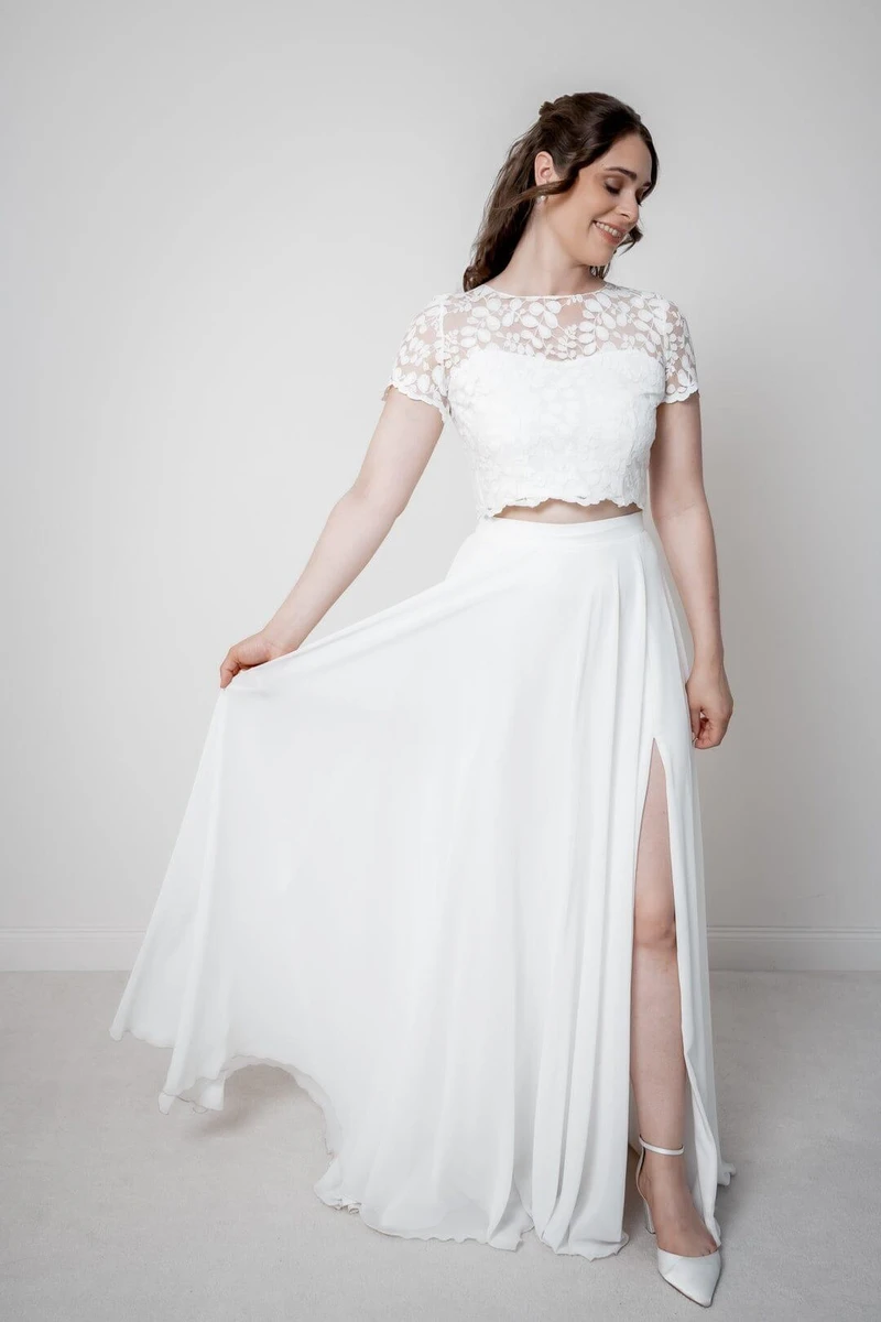 Váy cưới với phần trên là áo croptop cổ ren và phần dưới là chân váy dài xẻ cao
