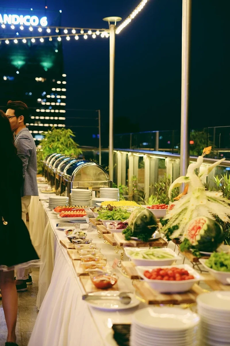 Tiệc buffet ngoài trời trên sân thượng với quầy món ăn được trang trí đẹp mắt cho tiệc cưới