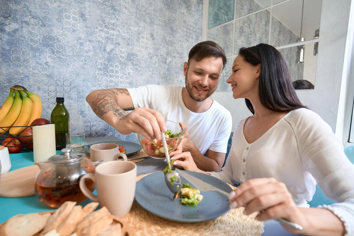 Cặp đôi hạnh phúc cùng nhau thưởng thức món ăn lành mạnh tại bàn ăn