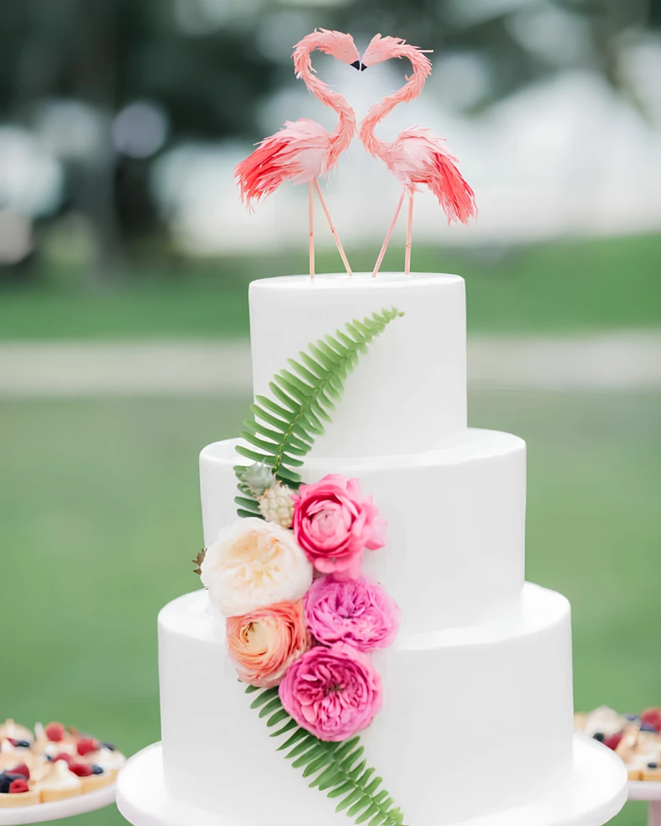 Với phần hình ảnh cây cỏ tươi, lá dương xỉ và hoa hồng đơn giản, chiếc bánh này gây chú ý phần chóp với đôi chim hồng hạc, tượng trưng cho tình yêu đôi lứa