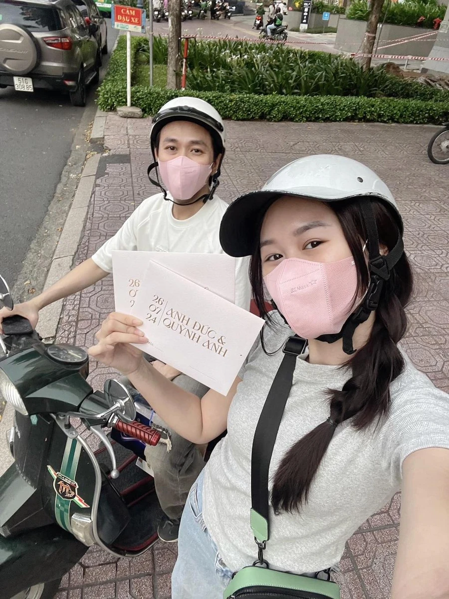 Cặp đôi đeo khẩu trang đi xe máy cùng nhau để phát thiệp cưới tận tay cho bạn bè