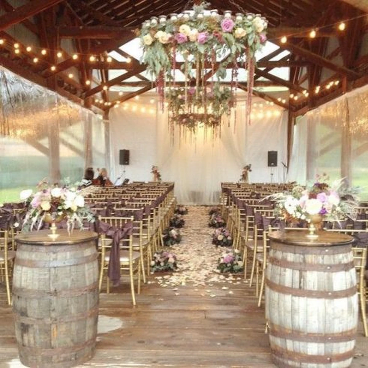 Lối đi lễ cưới trong nhà phong cách rustic với hoa treo và ánh đèn ấm áp