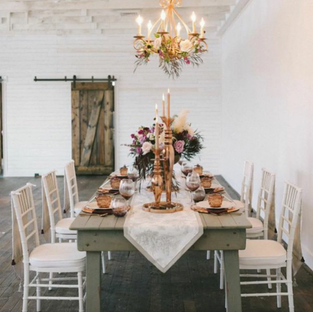 Bàn tiệc cưới phong cách rustic với chân nến vàng và hoa tươi trang nhã