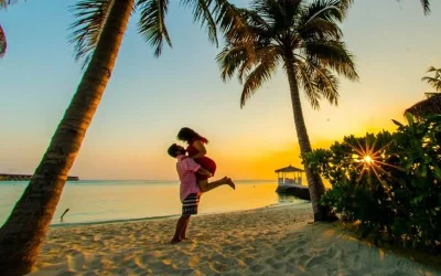 hình ảnh cặp đôi đang ôm nhau giữa biển với các hàng dừa trong hoàng hôn